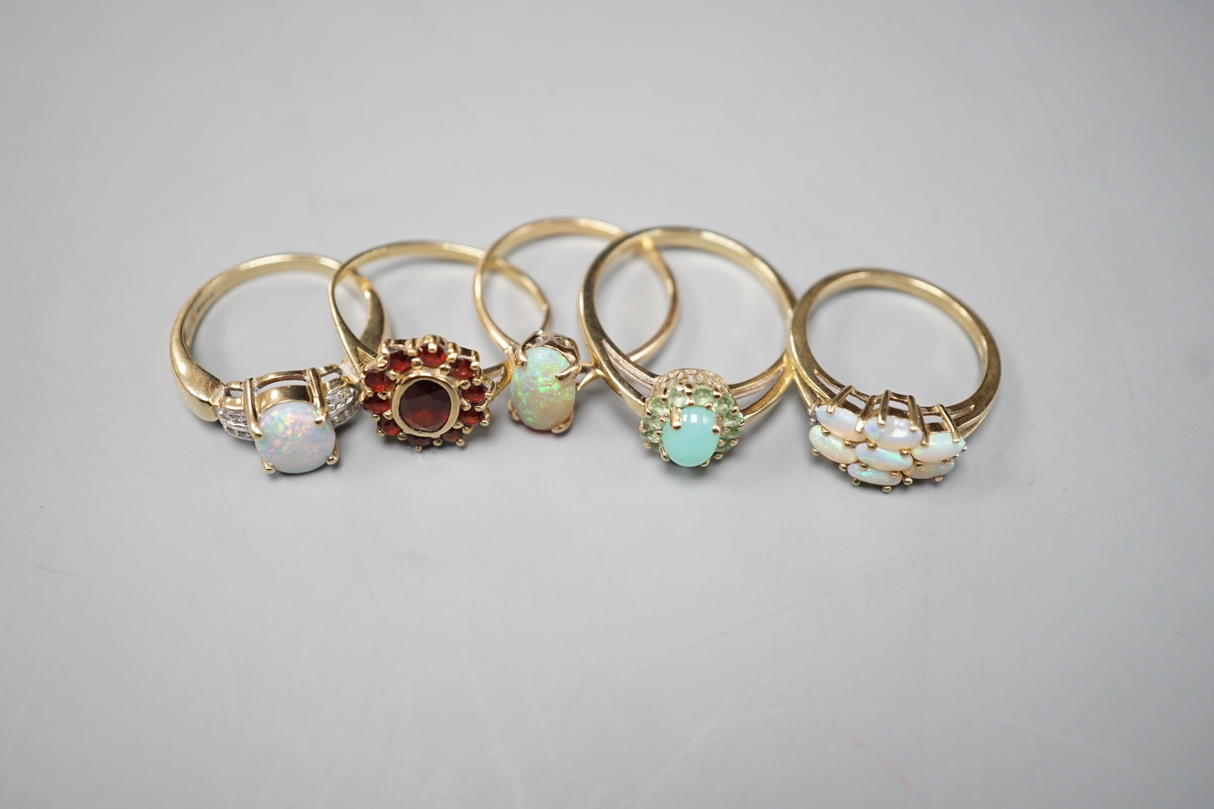 Five assorted modern 9ct gold and gem set dress rings, including white opal and diamond chip cluster, white opal cluster and garnet cluster
